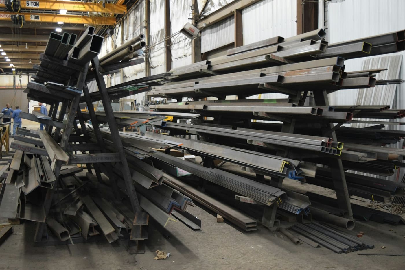 Steel beams and channel stacked on racks in a warehouse.